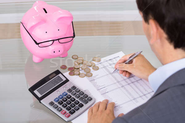 Man calculating savings and costs Stock photo © AndreyPopov