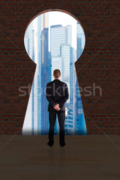 Businessman Looking At City Buildings Through Key Hole Stock photo © AndreyPopov