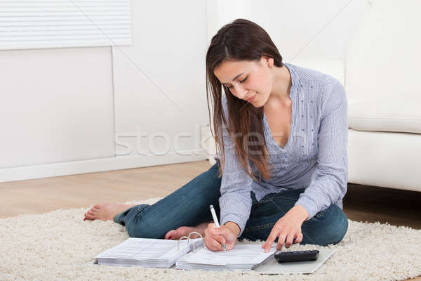 Woman Calculating Home Finances On Rug Stock photo © AndreyPopov