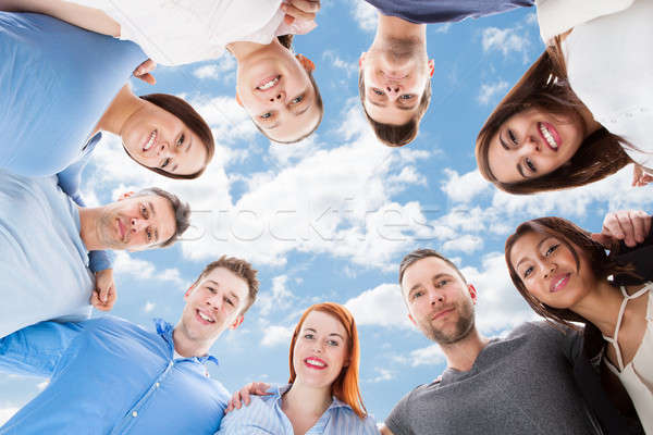 Happy Multiethnic Friends Forming Huddle Against Sky Stock photo © AndreyPopov