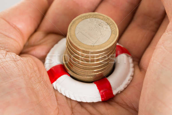 Person Holding Coins And Lifebelt Stock photo © AndreyPopov