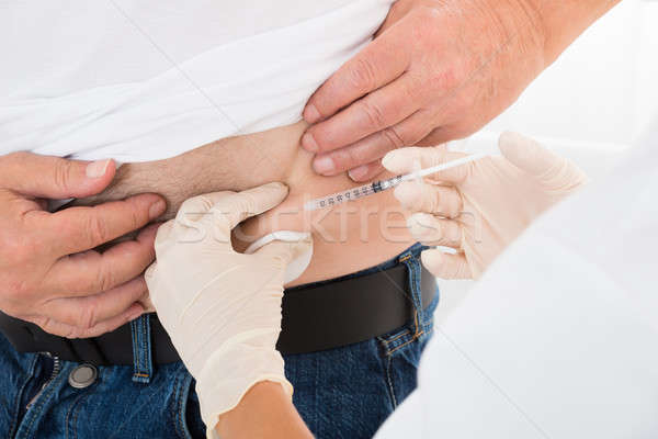 Doctor Injecting Stomach Of Diabetic Patient Stock photo © AndreyPopov