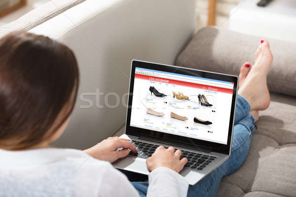 Kobieta zakupy online posiedzenia kanapie laptop Internetu Zdjęcia stock © AndreyPopov