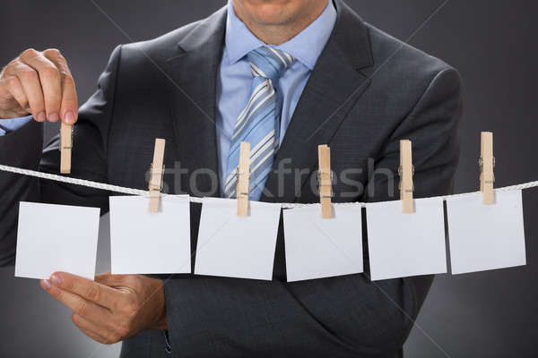 Businessman Pinning Blank Paper On Clothesline Stock photo © AndreyPopov