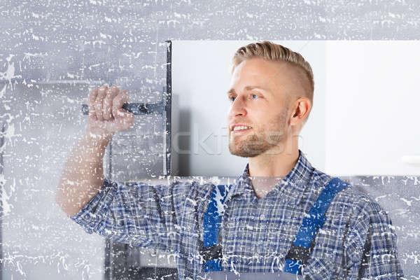 Worker Cleaning Glass Window With Squeegee Stock photo © AndreyPopov