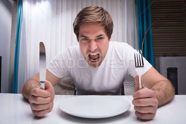Stock photo: Angry Man Holding Knife And Fork
