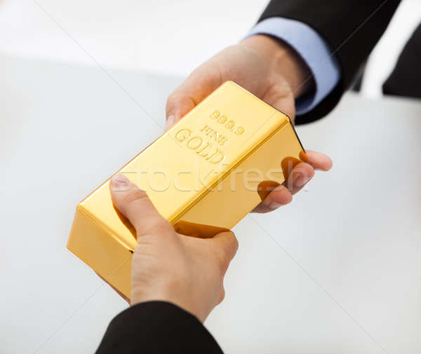 Business people exchanging golden bar Stock photo © AndreyPopov