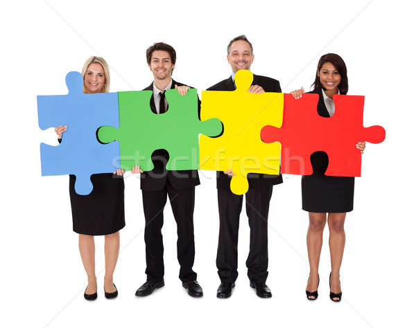 Group of business people assembling puzzle Stock photo © AndreyPopov