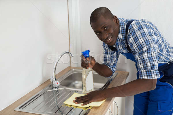 Stock photo: Janitor Cleaning Kitchen Worktop