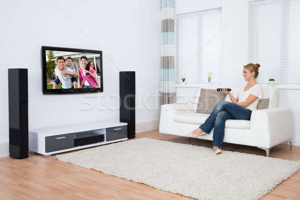 женщину Смотря телевизор сидят диван Сток-фото © AndreyPopov
