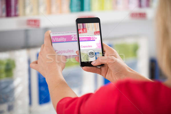Woman Photographing Capsule Packet In Store Stock photo © AndreyPopov