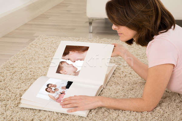 Donna guardando photo album tappeto appartamento Foto d'archivio © AndreyPopov