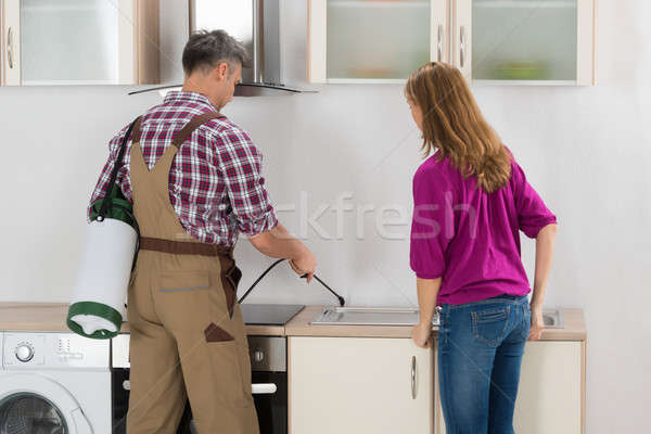 Worker Spraying Insecticide In Kitchen Stock photo © AndreyPopov