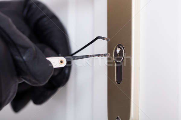 Stock photo: Burglar With Gloves Picking Lock