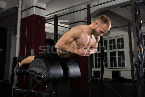 Man Doing Core Exercise On Exercise Equipment Stock photo © AndreyPopov
