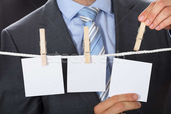 Businessman Pinning Blank Paper On Clothesline Stock photo © AndreyPopov