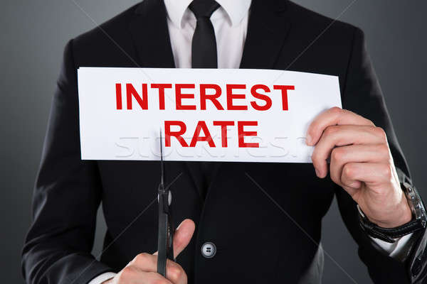 Businessman Cutting Paper With Interest Rate Text Stock photo © AndreyPopov