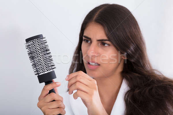 Mulher roupão de banho pente olhando cabelo Foto stock © AndreyPopov