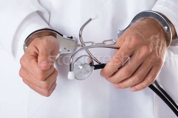 Imagine de stoc: Arestat · medici · mână · stetoscop · cătuşe