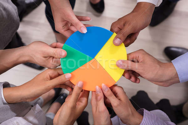 Businesspeople Holding Pie Chart Stock photo © AndreyPopov