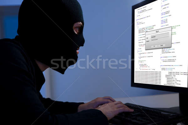 Hacker downloading information off a computer Stock photo © AndreyPopov