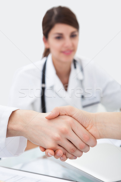 Doctors Shaking Hands At Desk Stock photo © AndreyPopov