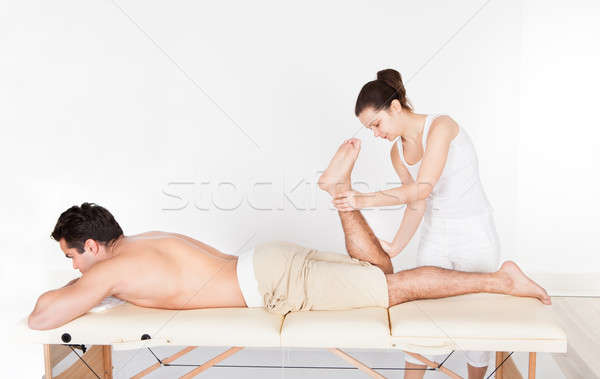 Woman Massaging Man's Foot Stock photo © AndreyPopov
