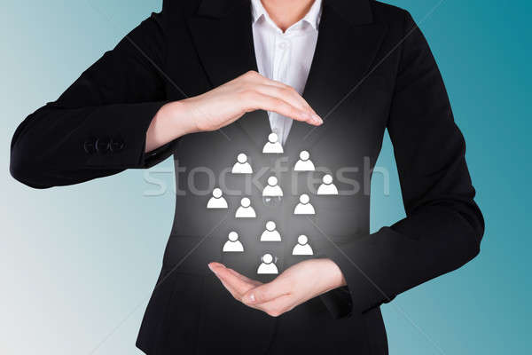 Businesswoman Protecting Human Icons Representing Leadership Stock photo © AndreyPopov