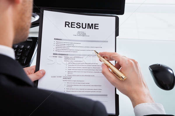 Businessman Analyzing Resume At Office Desk Stock photo © AndreyPopov
