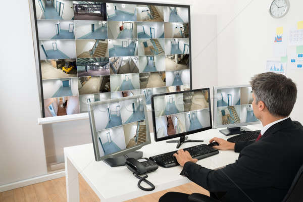 Homme contrôle chambre regarder cctv Photo stock © AndreyPopov