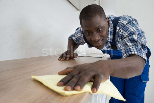 Stock photo: Janitor Cleaning Kitchen Worktop