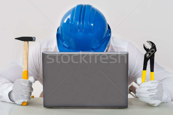 Technician Holding Hammer And Plier With Laptop Stock photo © AndreyPopov