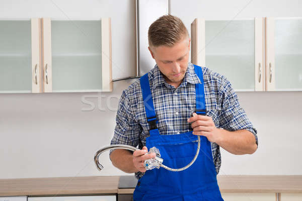 Plumber With Faucet In The Kitchen Room Stock photo © AndreyPopov