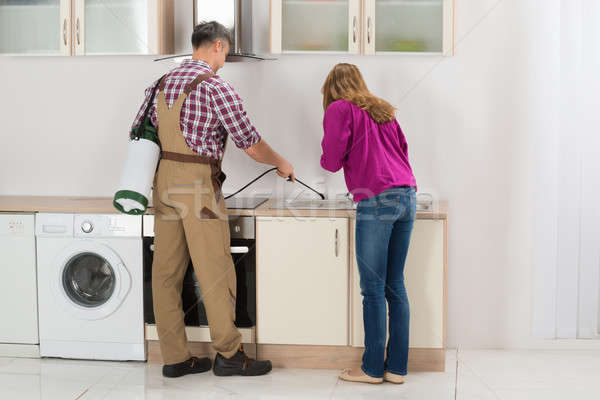 Worker Spraying Insecticide In Kitchen Stock photo © AndreyPopov