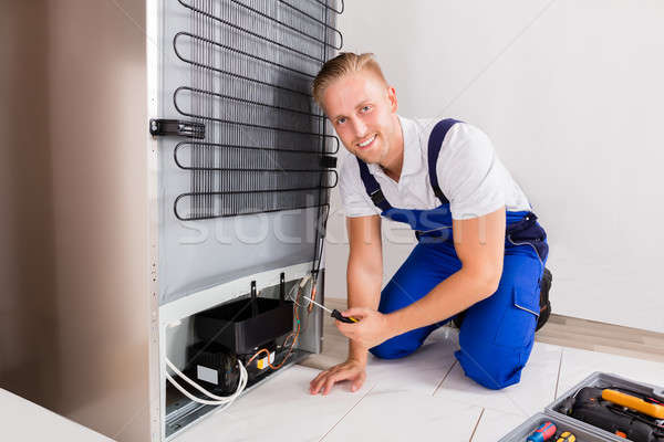 Masculino técnico geladeira jovem chave de fenda casa Foto stock © AndreyPopov