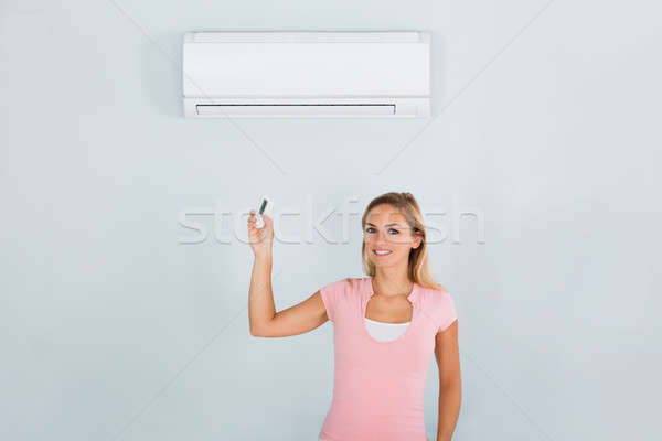 Frau Klimagerät Remote Porträt glücklich halten Stock foto © AndreyPopov
