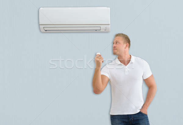 Stockfoto: Man · airconditioner · jonge · man · afstandsbediening · home