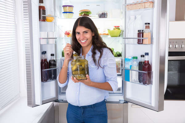 Mulher jovem alimentação jarra geladeira mulher casa Foto stock © AndreyPopov