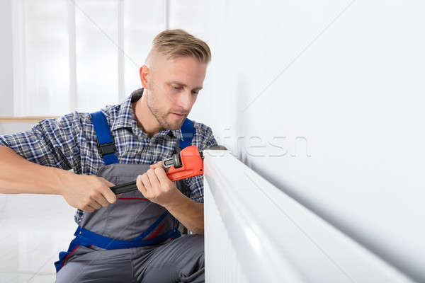 Férfi vízvezetékszerelő megjavít termosztát franciakulcs közelkép Stock fotó © AndreyPopov
