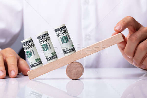 Person Balancing Currency Notes On Seesaw Stock photo © AndreyPopov