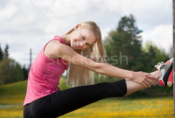 Young Happy Blonde Woman Stretching Leg Stock photo © AndreyPopov