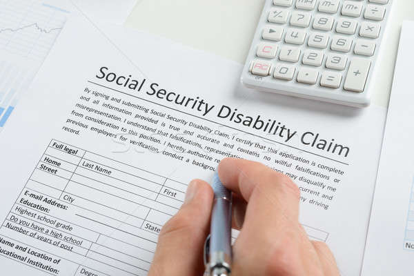 Person Hand With Pen Filling Social Security Disability Form Stock photo © AndreyPopov