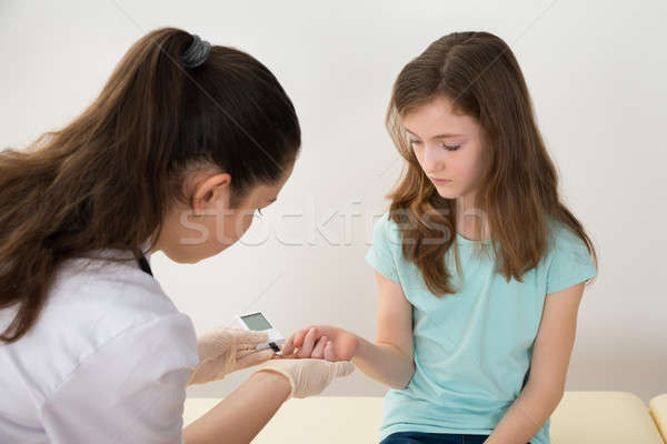 Doctor Measuring Blood Sugar Level Of Girl Stock photo © AndreyPopov