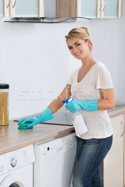 Nő takarítás konyhapult szivacs fiatal nő otthon Stock fotó © AndreyPopov