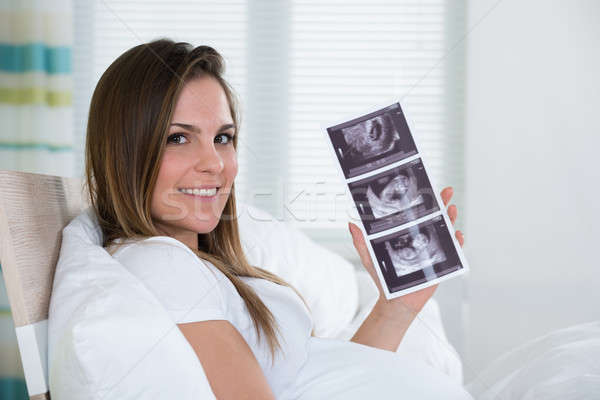 Stock photo: Young Woman Holding Ultrasound Photo
