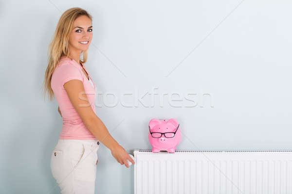 Femme thermostat tirelire radiateur souriant jeune femme [[stock_photo]] © AndreyPopov