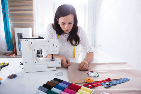 Stock photo: Fashion Designer Sewing Fabric With Needle