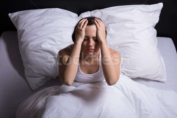 Femeie durere de cap şedinţei pat Imagine de stoc © AndreyPopov