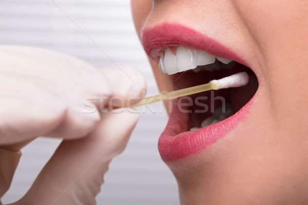 Dentist's Hand Taking Saliva Test From Woman's Mouth Stock photo © AndreyPopov