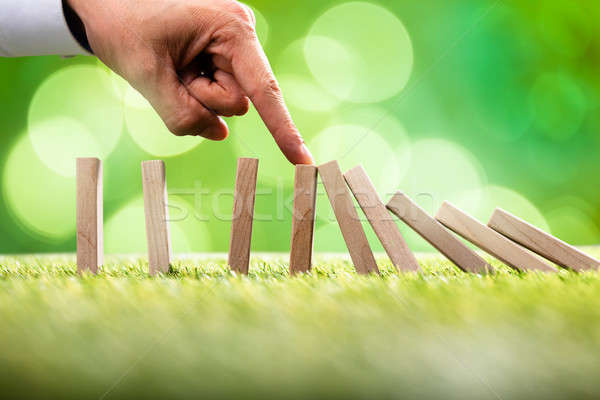 Person Stopping Falling Wooden Blocks Stock photo © AndreyPopov